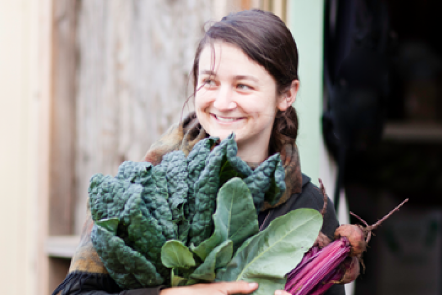 Student carrying produce and smiling